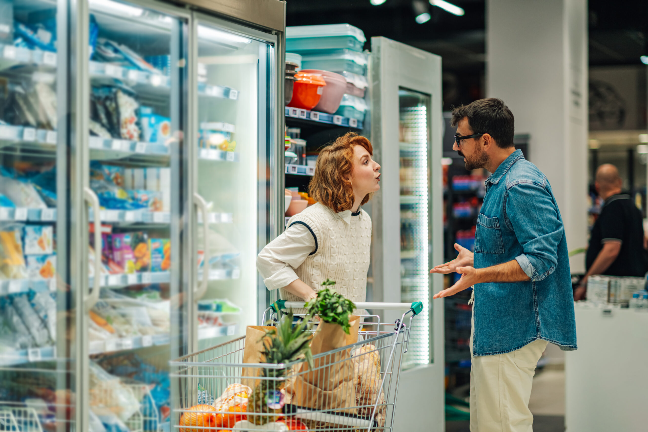Young couple arguing while shopping groceries in supermarket