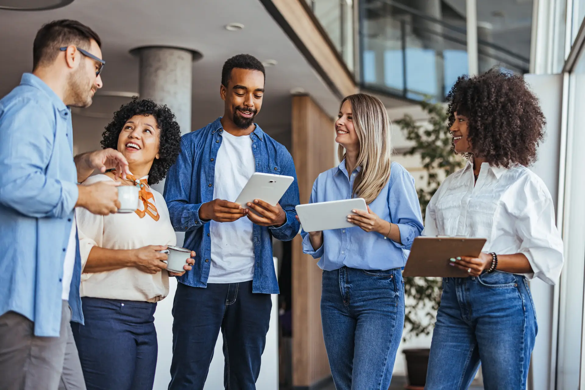 Diverse Team Engaged In Casual Office Discussion With Technology