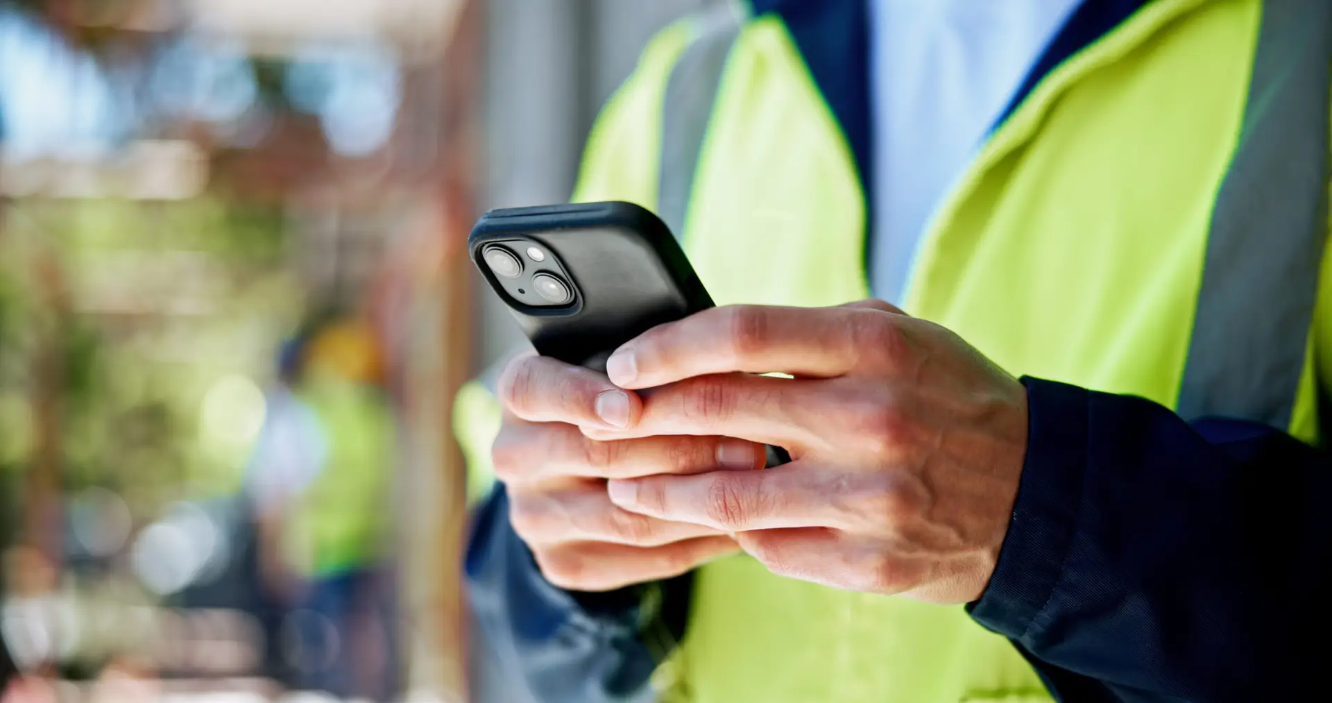 Hands, phone and construction site with texting, person or contact with info for building development. Engineer, smartphone and check with network, notification and mobile app at property in Spain