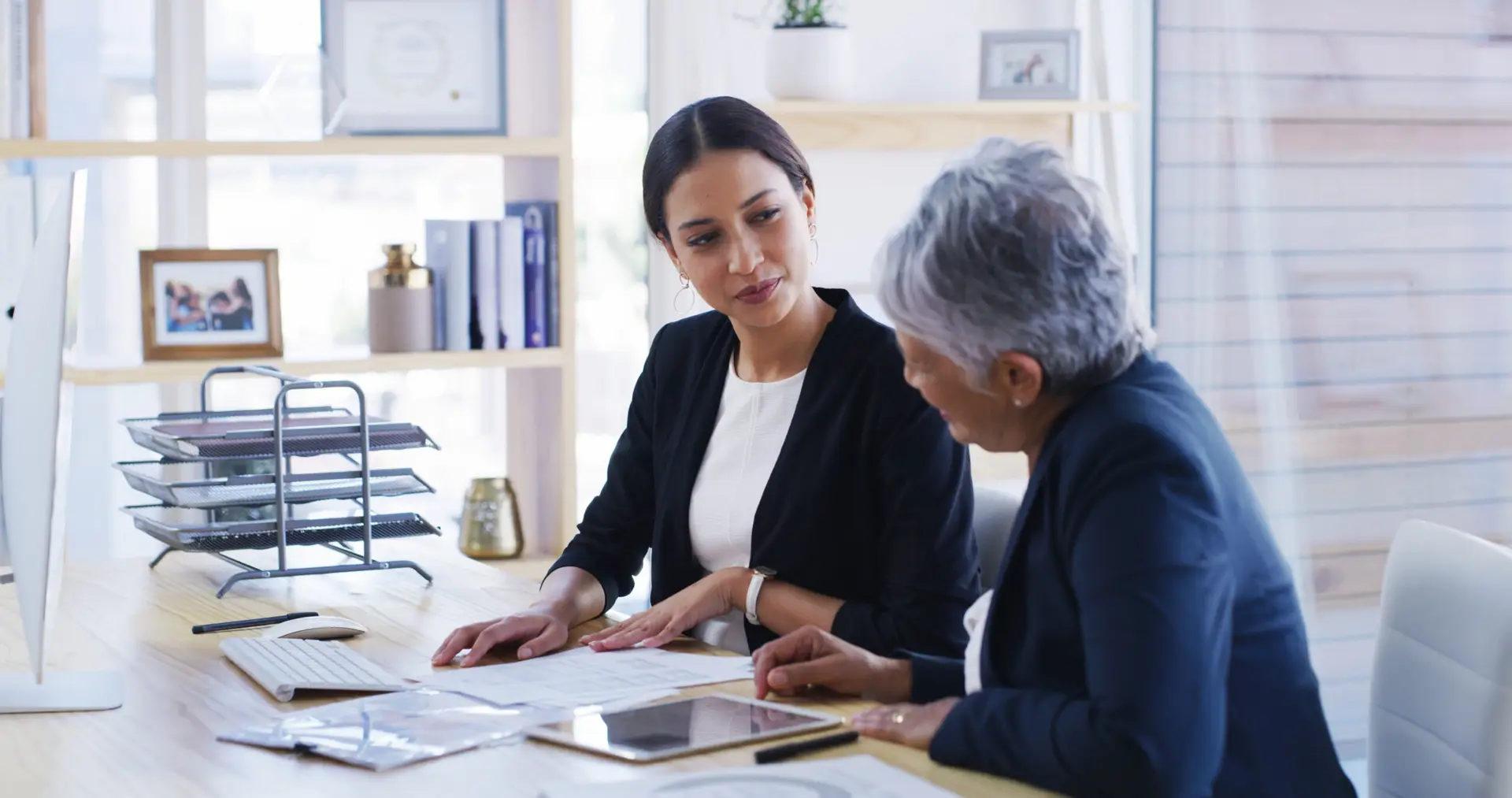 Elderly woman, lawyer and document in office for planning, debt settlement and legal guidance. Senior person, attorney and reading paperwork for retirement fund, asset protection and will information