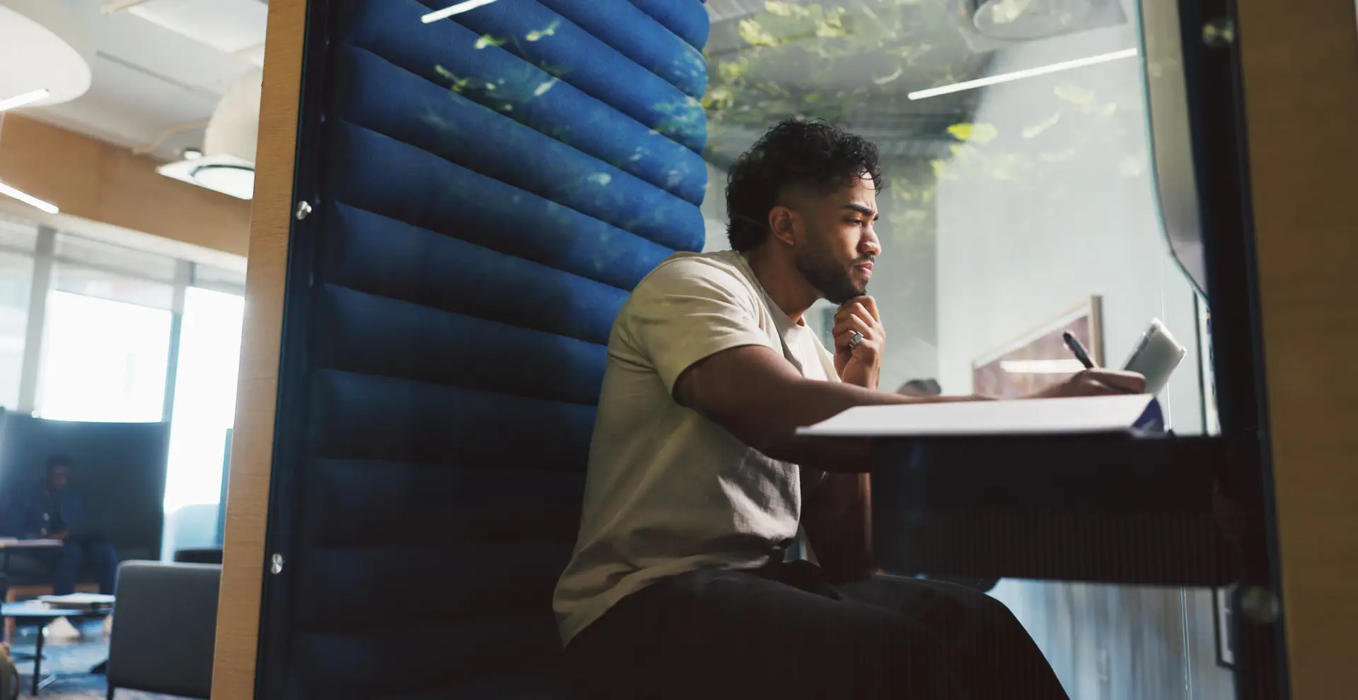 Creative, man and laptop with writing in booth with notes, brand manager and privacy for feedback. Soundproof, cubicle and person with proposal for ad campaign, digital marketing or research in pod