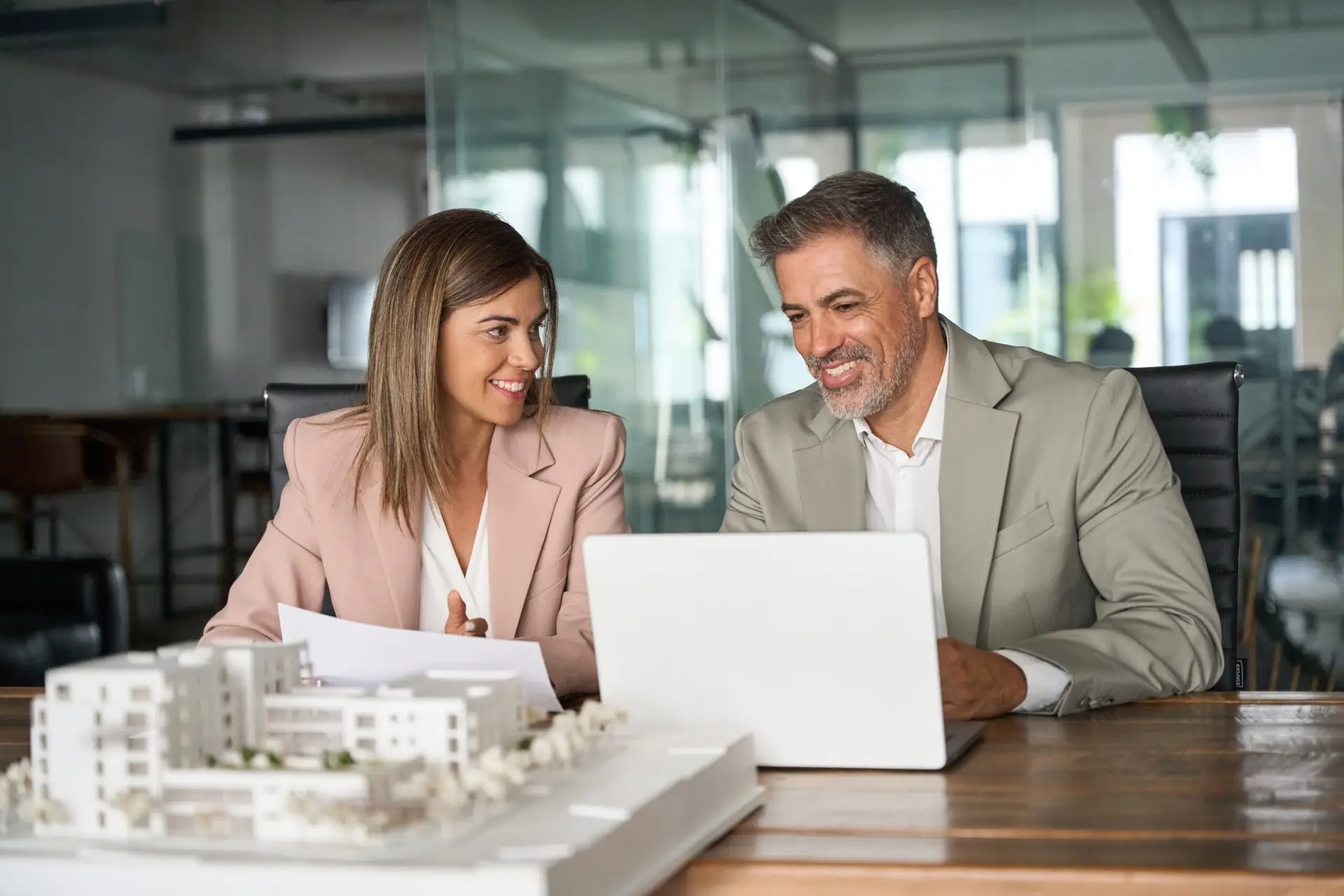 Real estate developers working on laptop discussing new development.