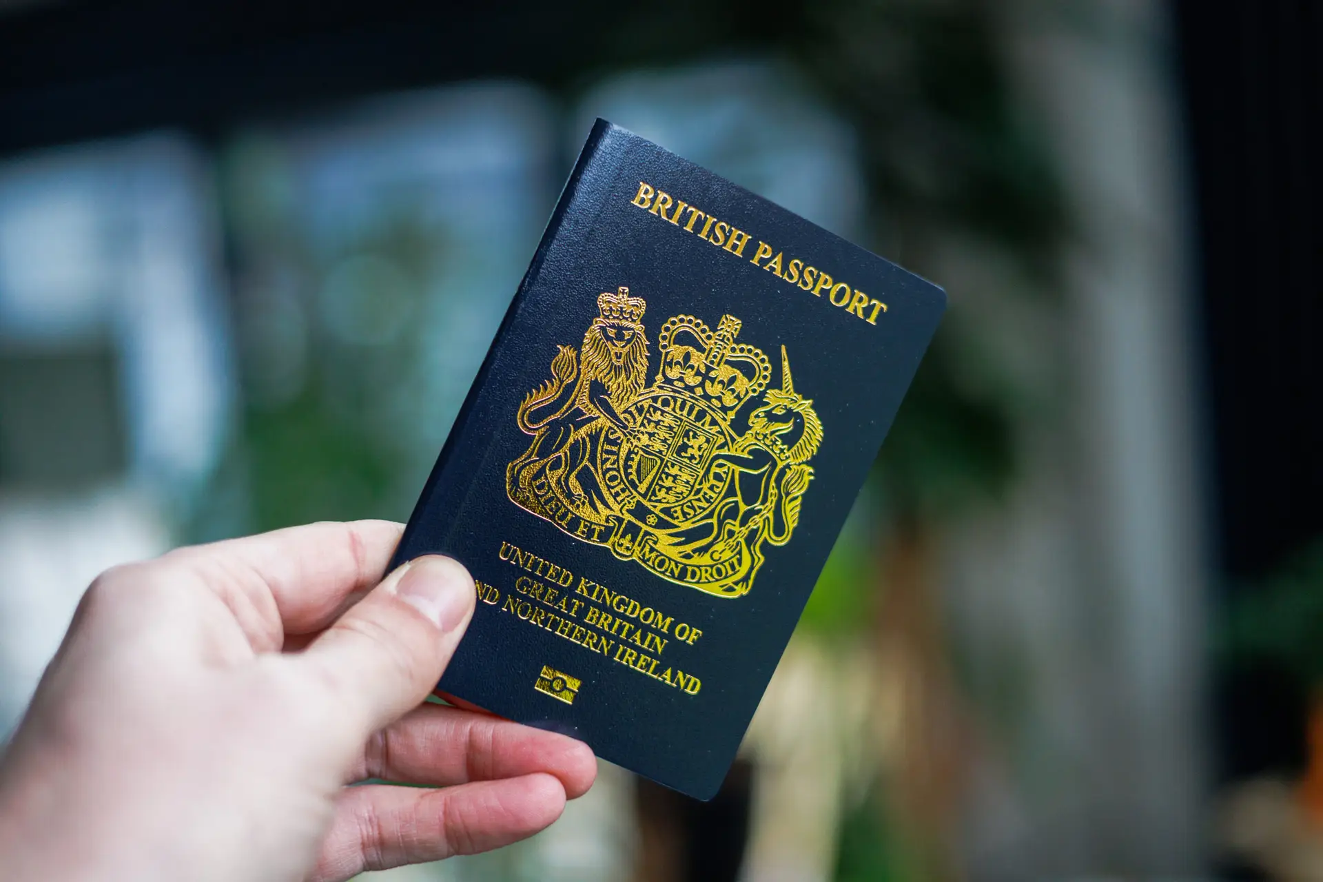 British passport held in hand in a modern lifestyle setting, representing travel, identity, and international mobility
