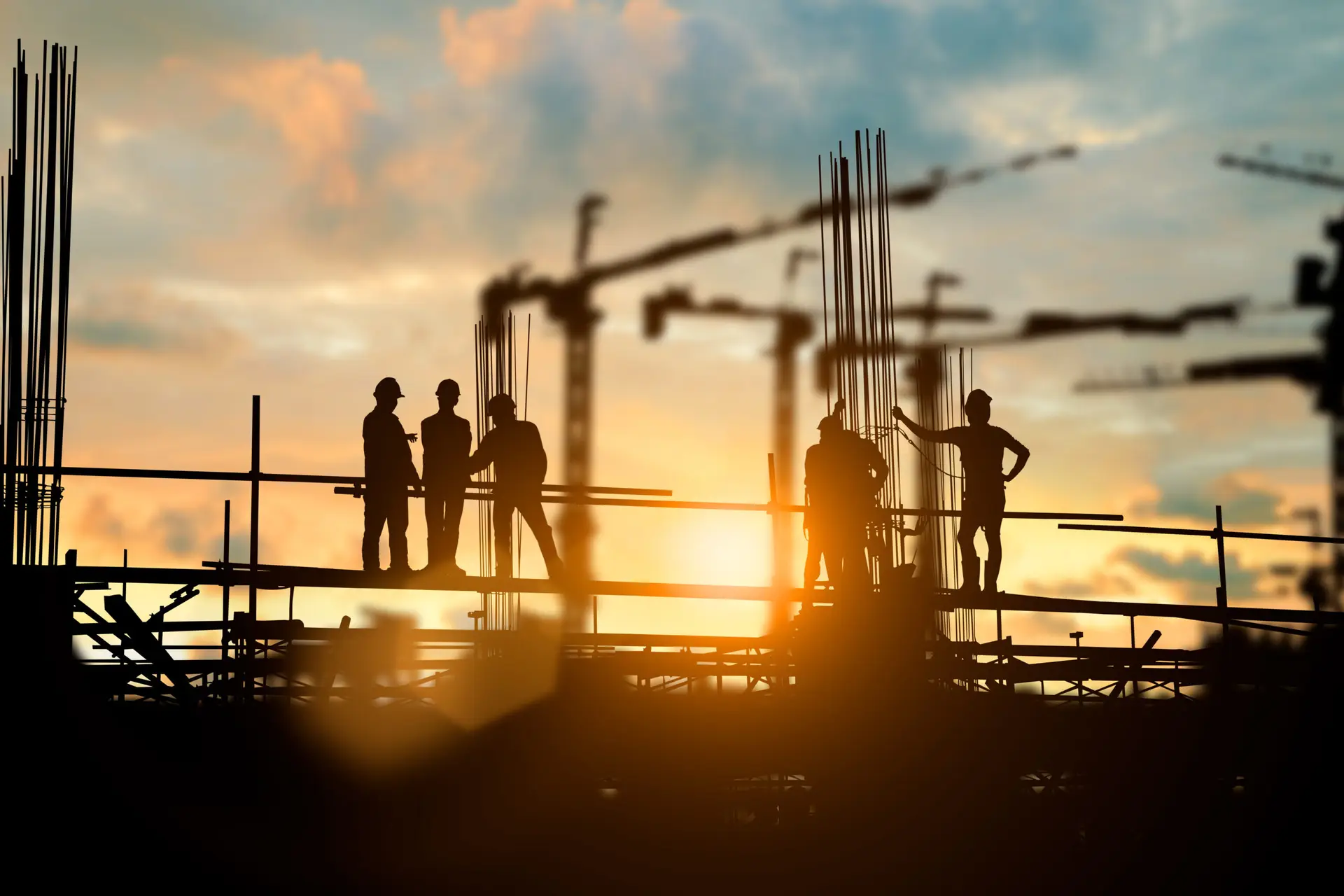 Silhouette of engineer and construction team working at site ove