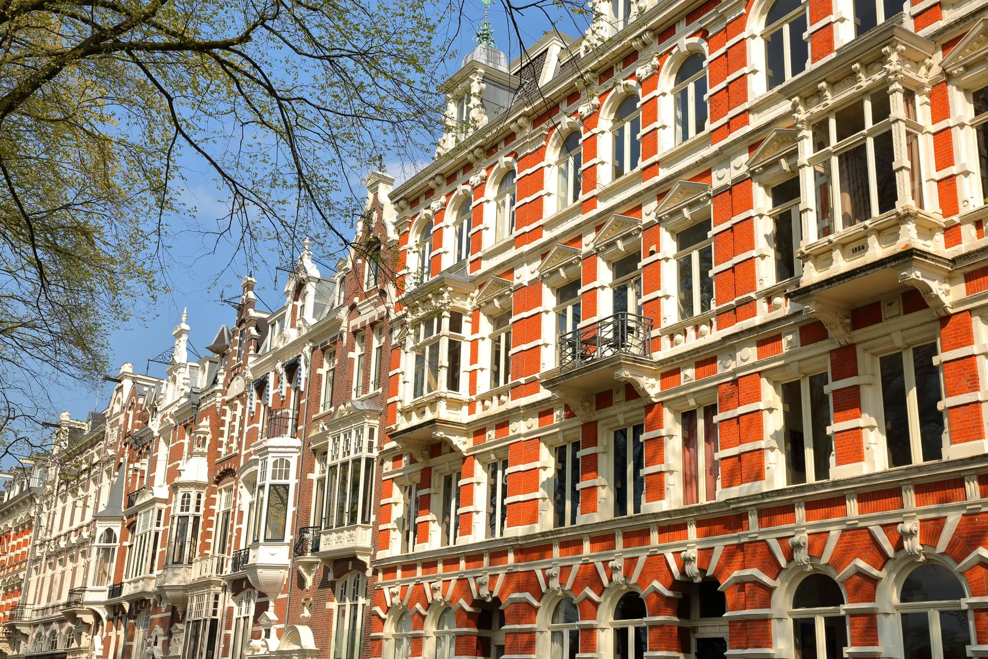 Traditional dutch old facades located on Weesperzijde Street along Amstel river, Amsterdam, Netherlands