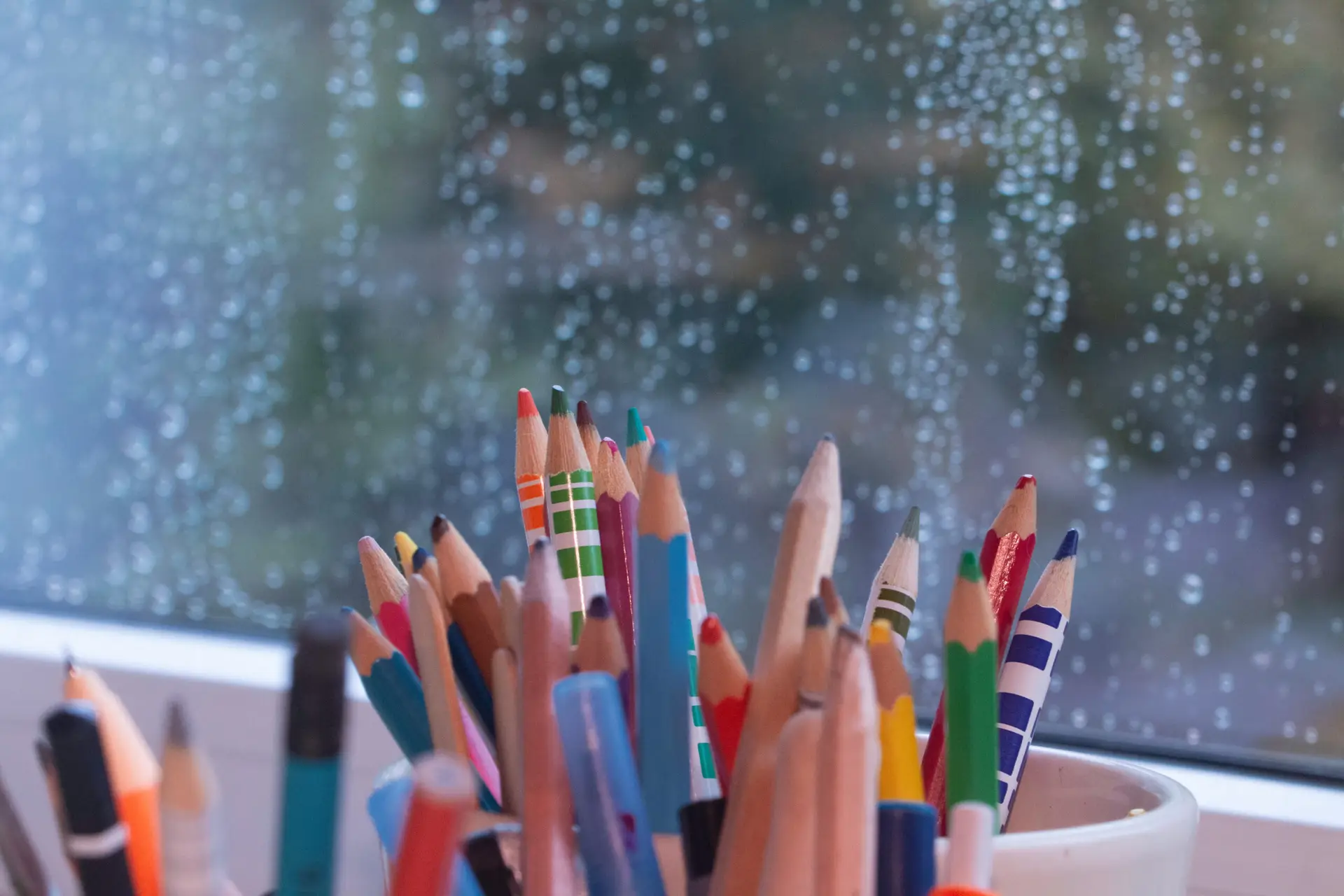 colourful pen image in front of the glass on a rainy day