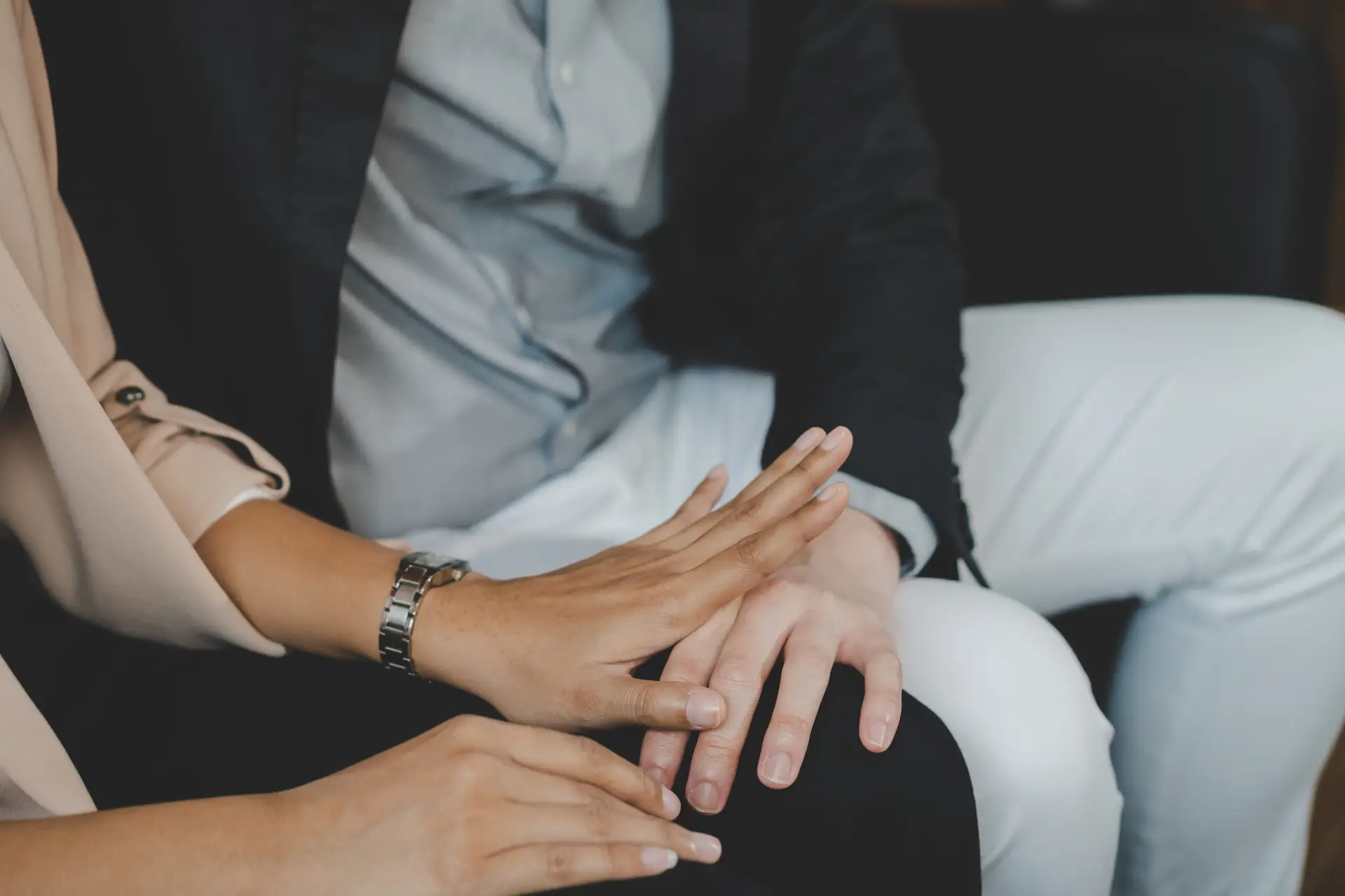 Unhappy asian young employee woman defending at hand of colleagues, man or boss touching her knee feeling disgusted and uncomfortable. Sexual harassment inappropriate at office, workplace concept.