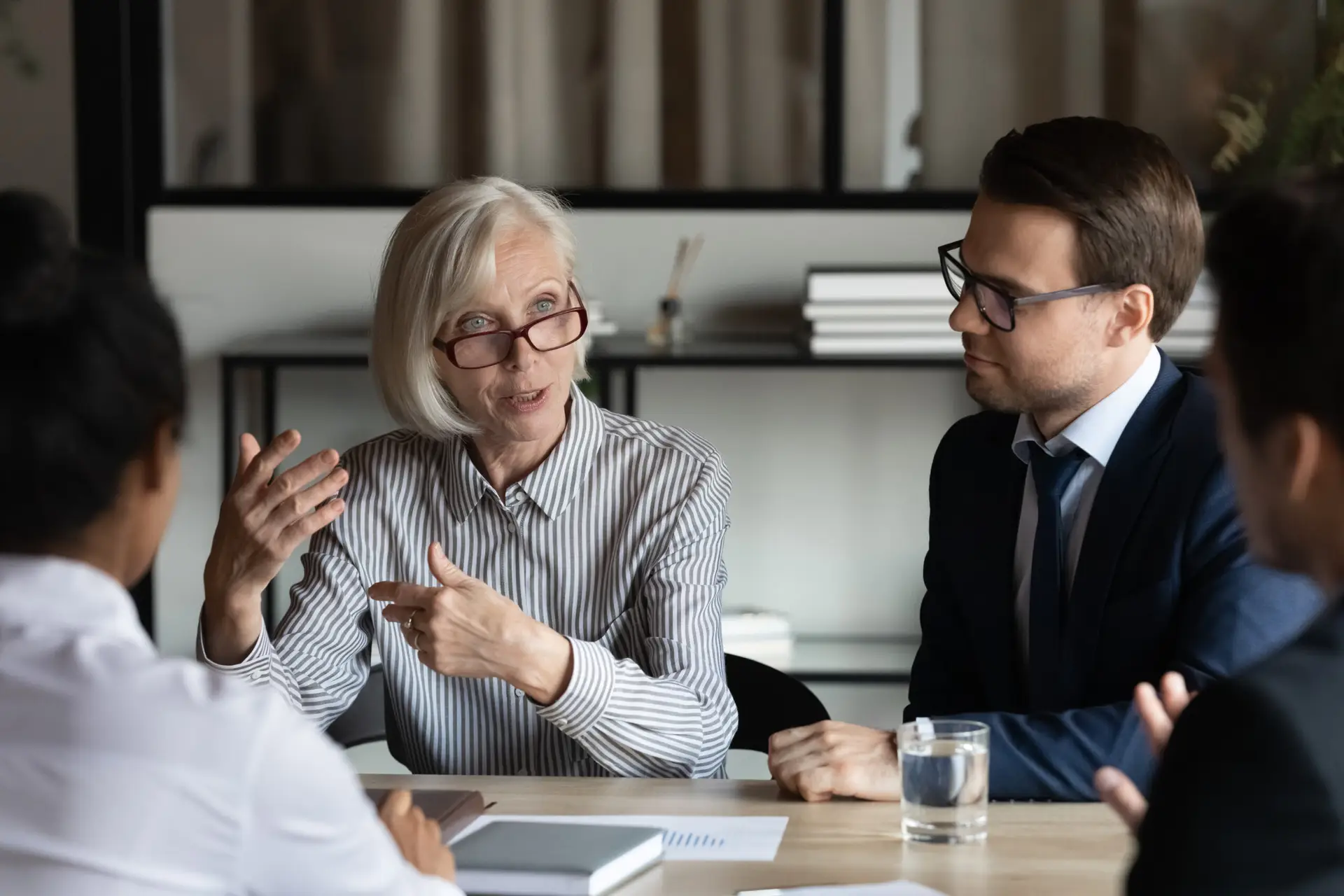 Middle aged mature mentor training interns, corporate coach teaching staff