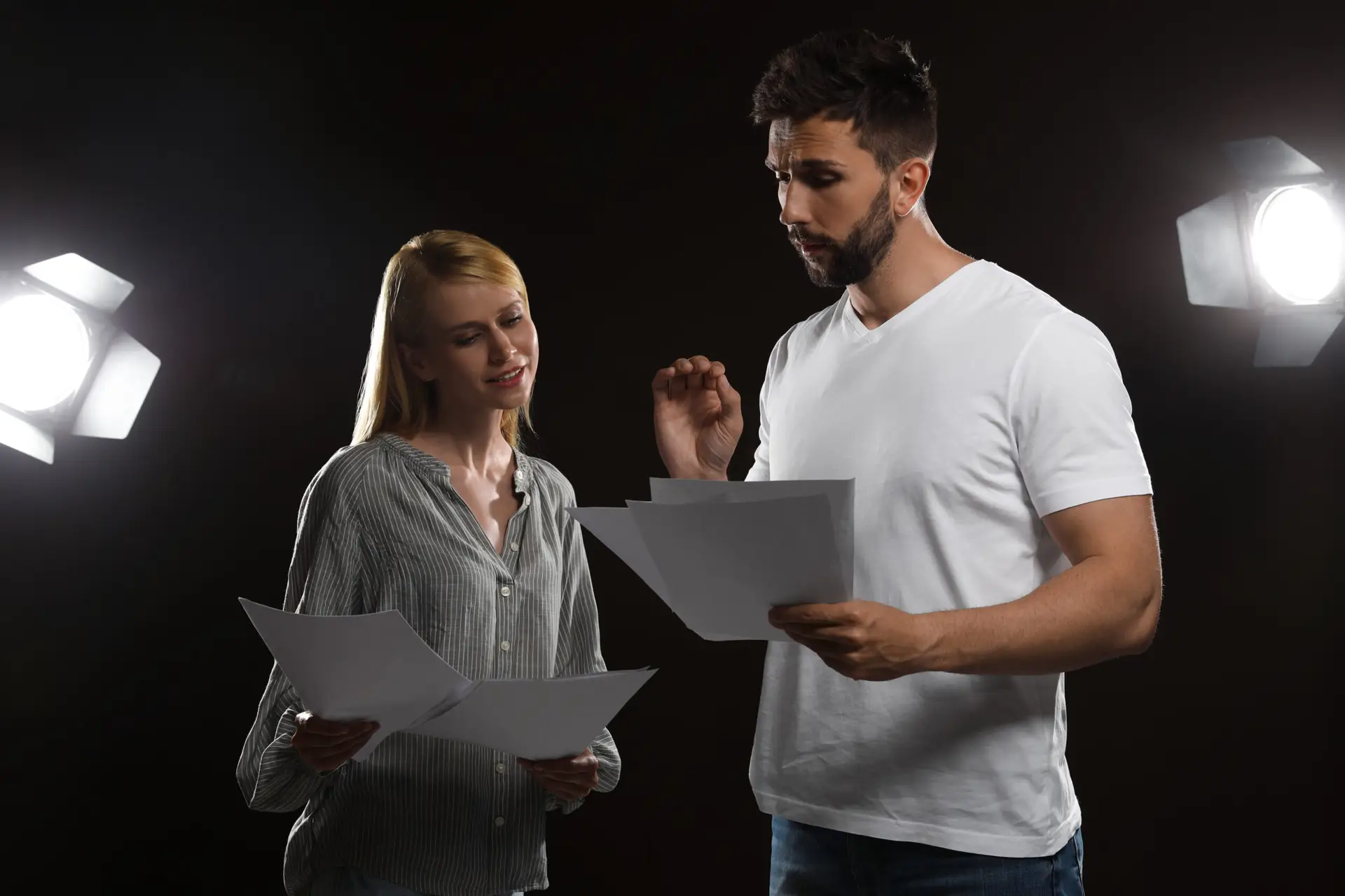 Professional actors reading their scripts during rehearsal in theatre
