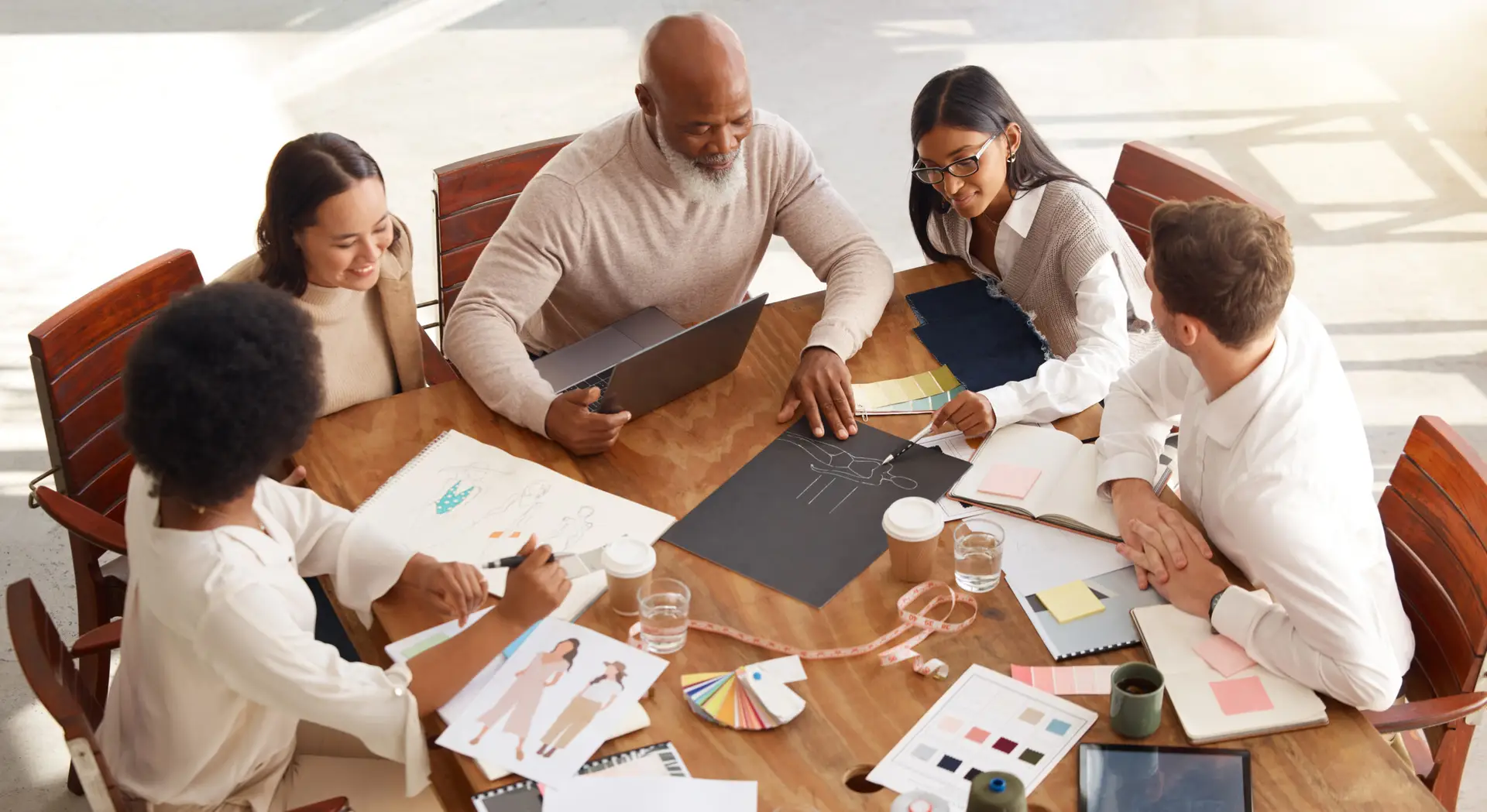 Creative business people, meeting and planning above in fashion design, brainstorming or strategy at office. Group of clothing designers in teamwork, project plan or color palette ideas for startup