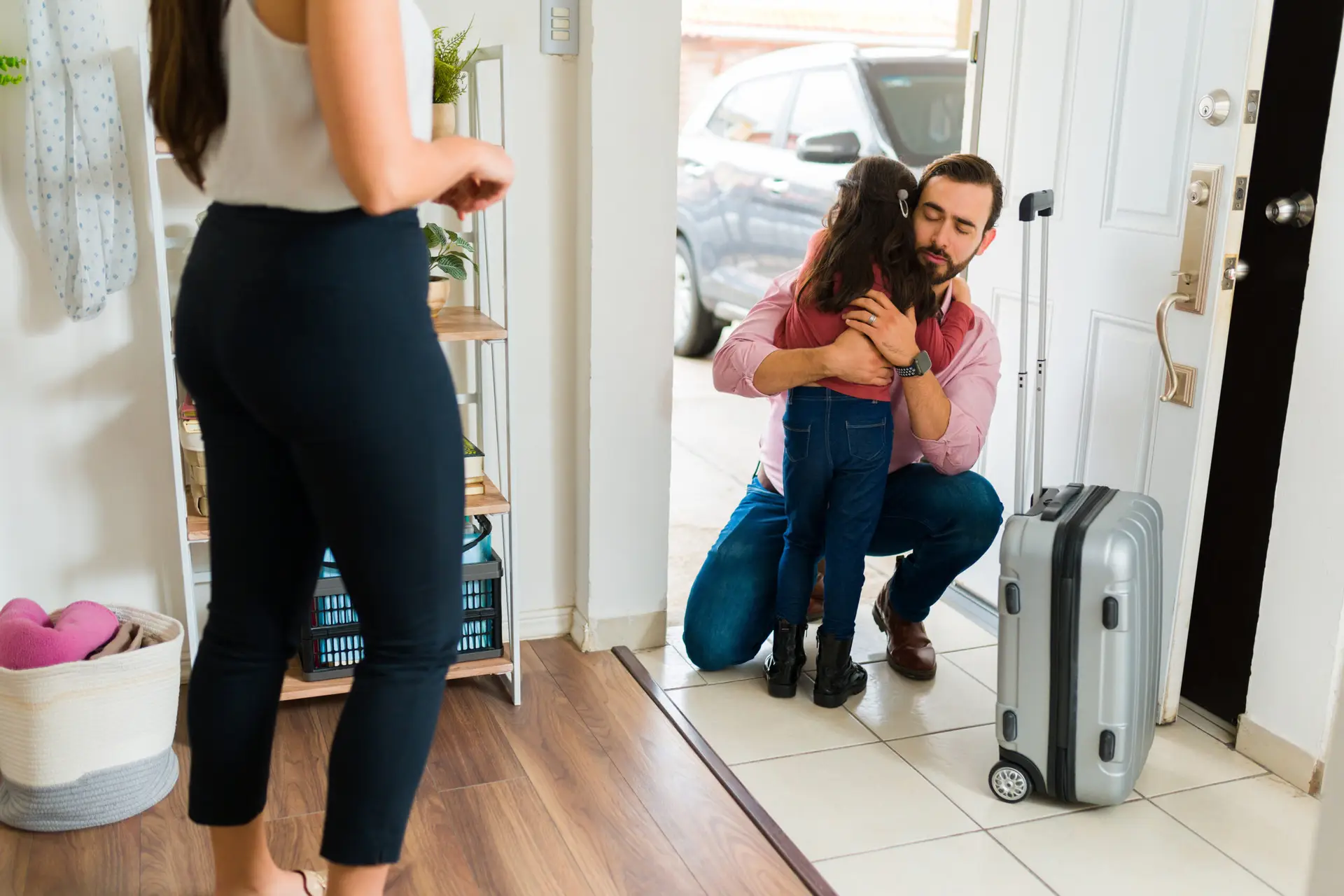 Upset young child hugging his dad before moving out