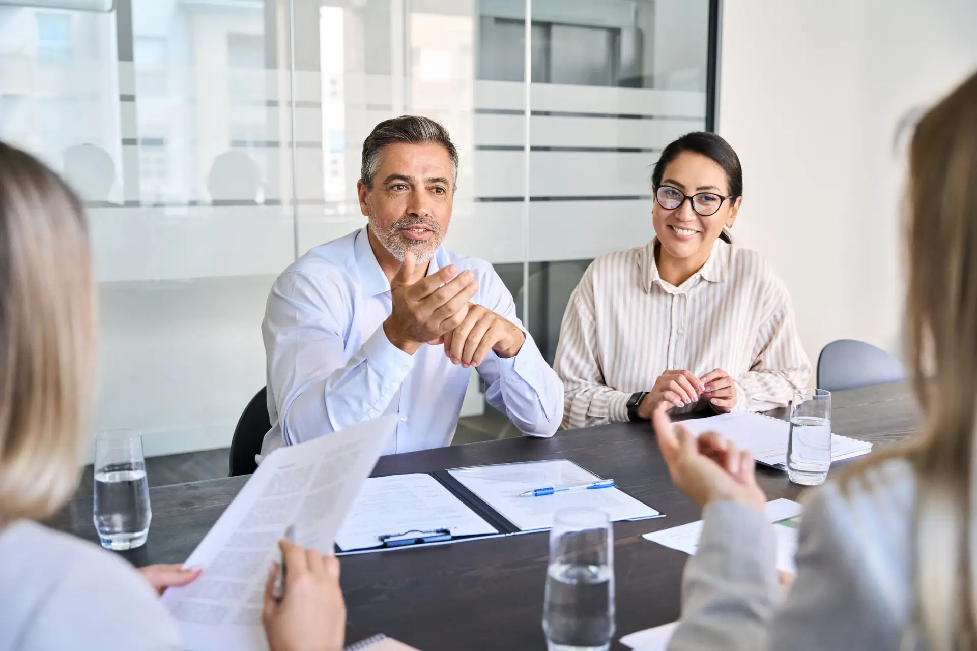 Diverse professional executive team people working at board meeting in office.