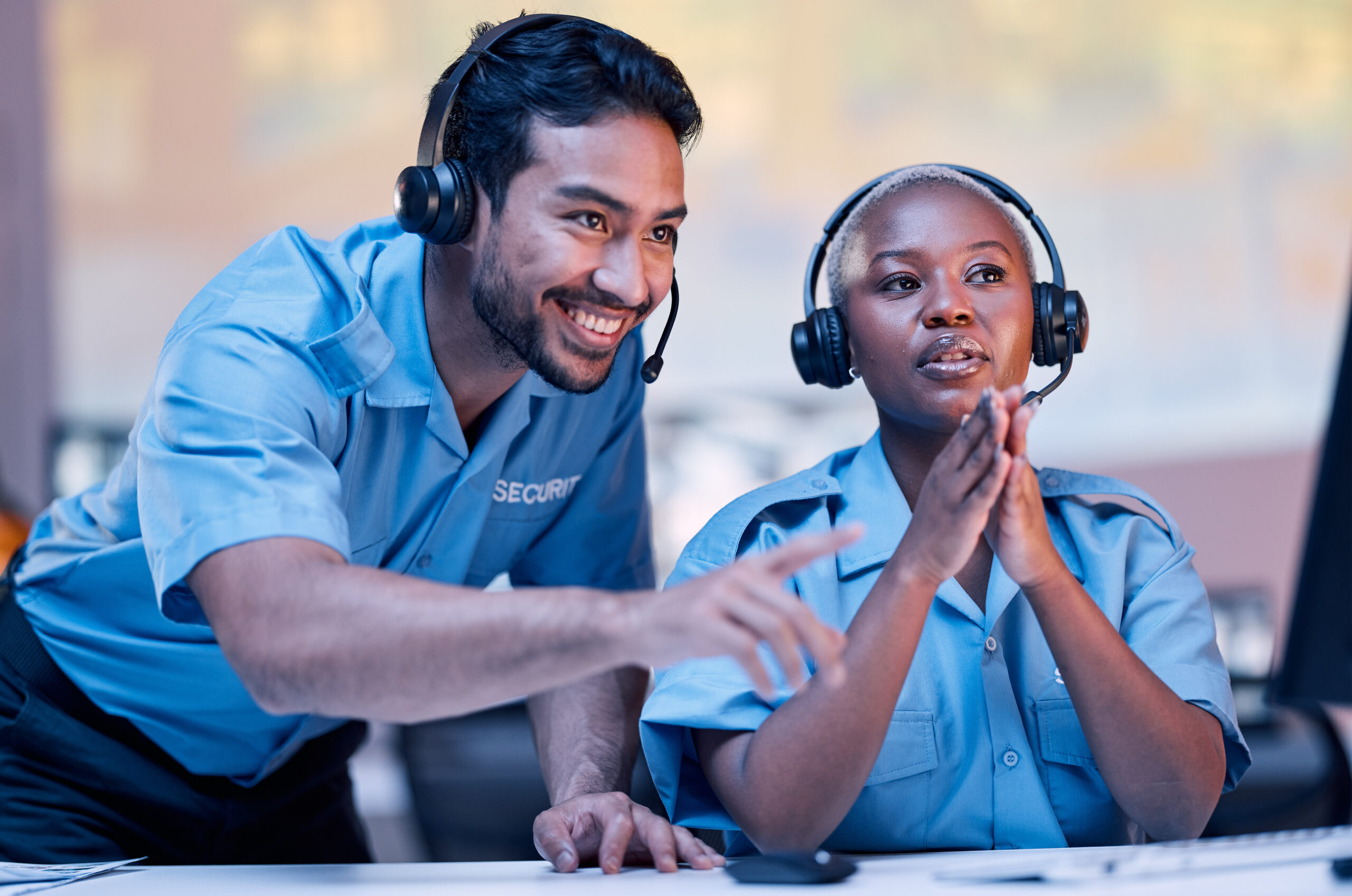 Security, surveillance and a man training a black woman in a control room for safety or law enforcement. Teamwork, office and headset with a private guard team watching a monitor for crime prevention