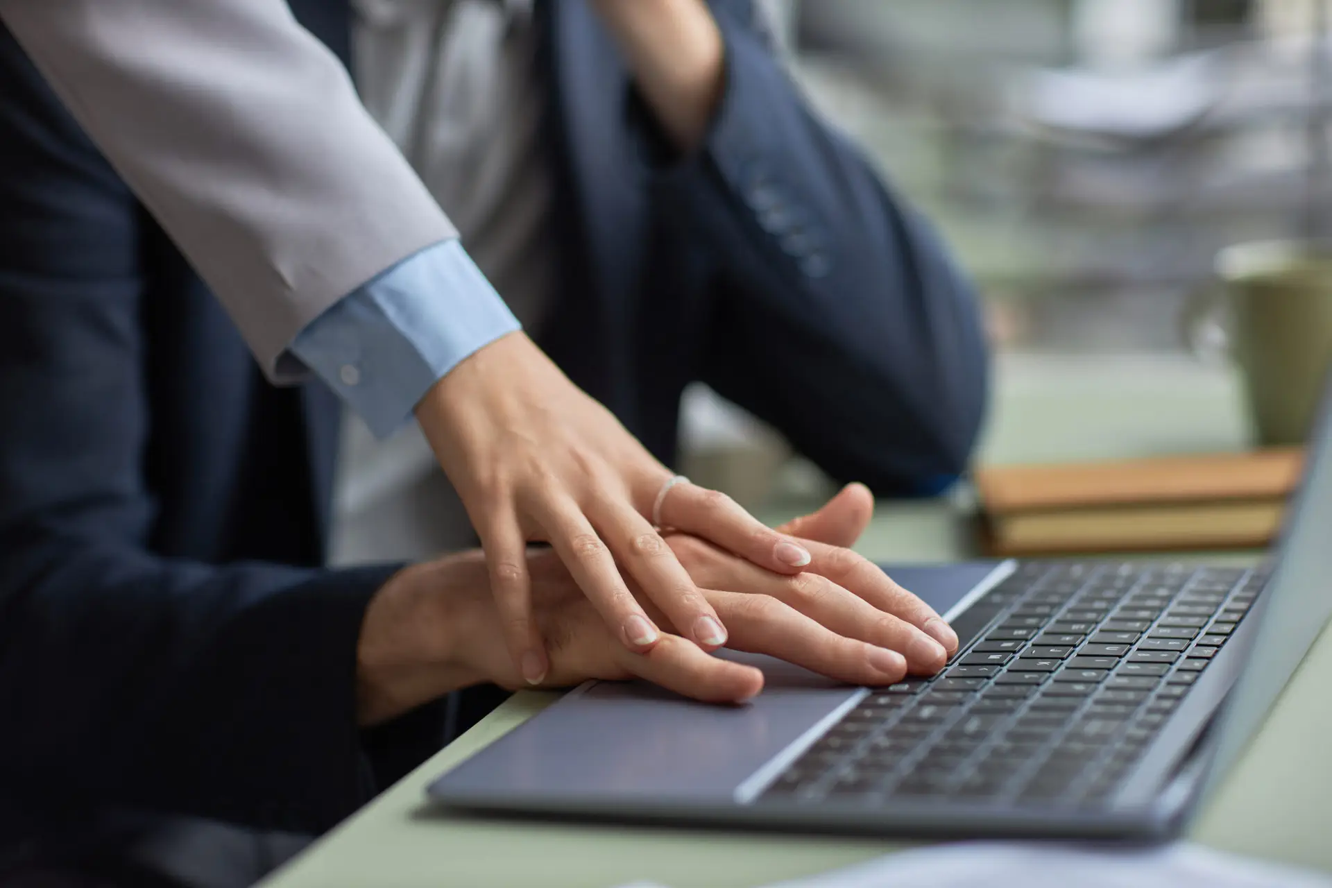 Young woman stroking hand of male colleague in office