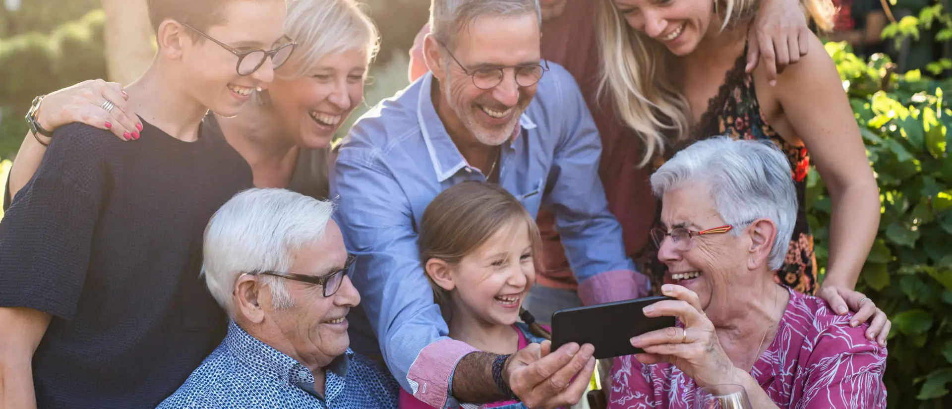 During a bbq, the family have fun sharing a video on a phone