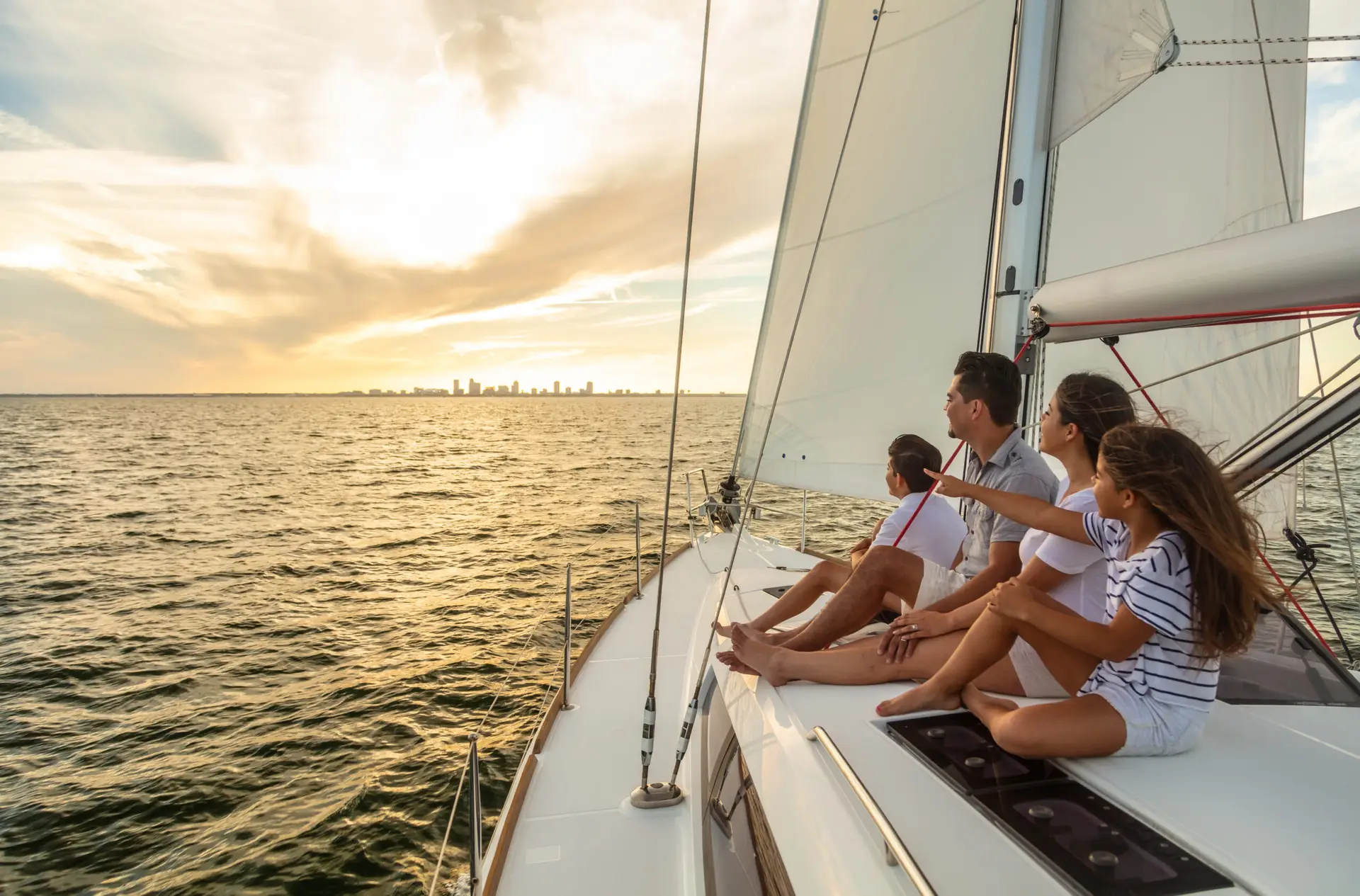 Family sailing vacation at sunset on luxury yacht