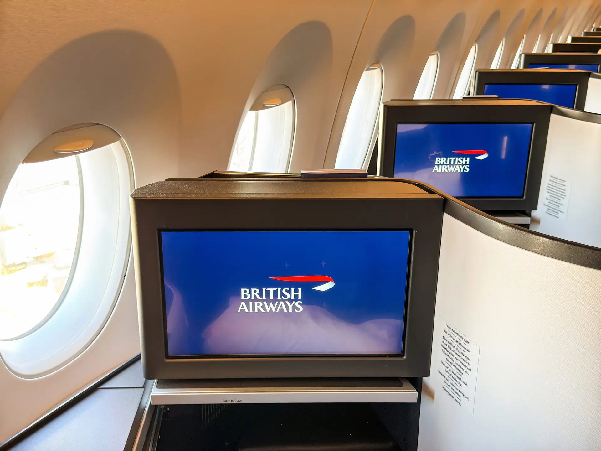 London, England, UK - 20 May 2025: Row of television screens in front of seats in the Club World business cabin of a British Airways jet