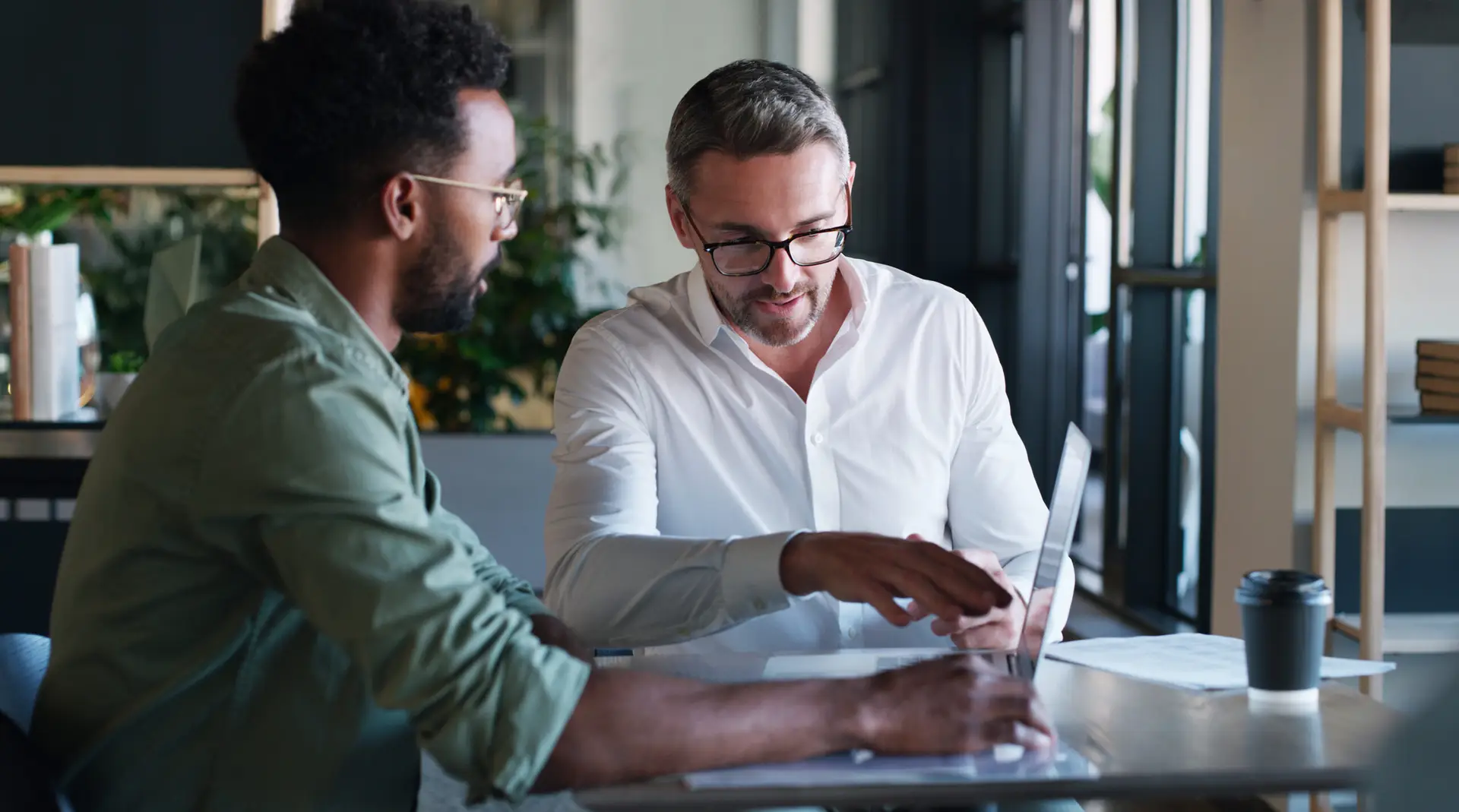 Mentor, reading and men with laptop, office and help with article on website, creative or journalism. Intern, learning and people with tech for story, teamwork and editing with manager in newsroom