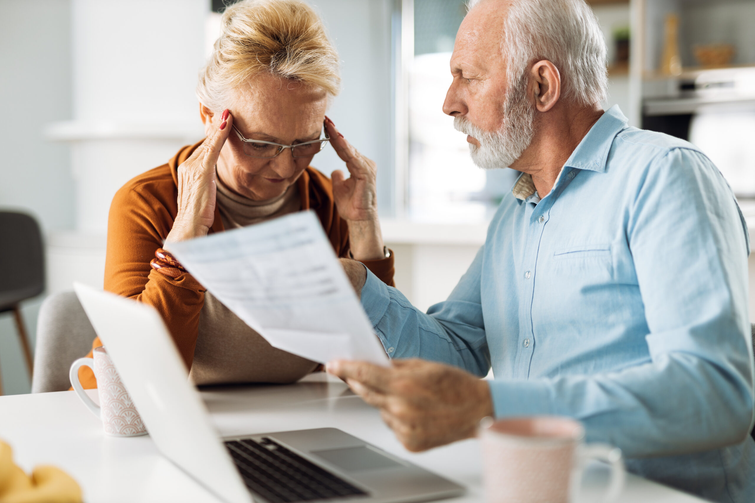 Frustrated senior couple arguing about their home finances at home