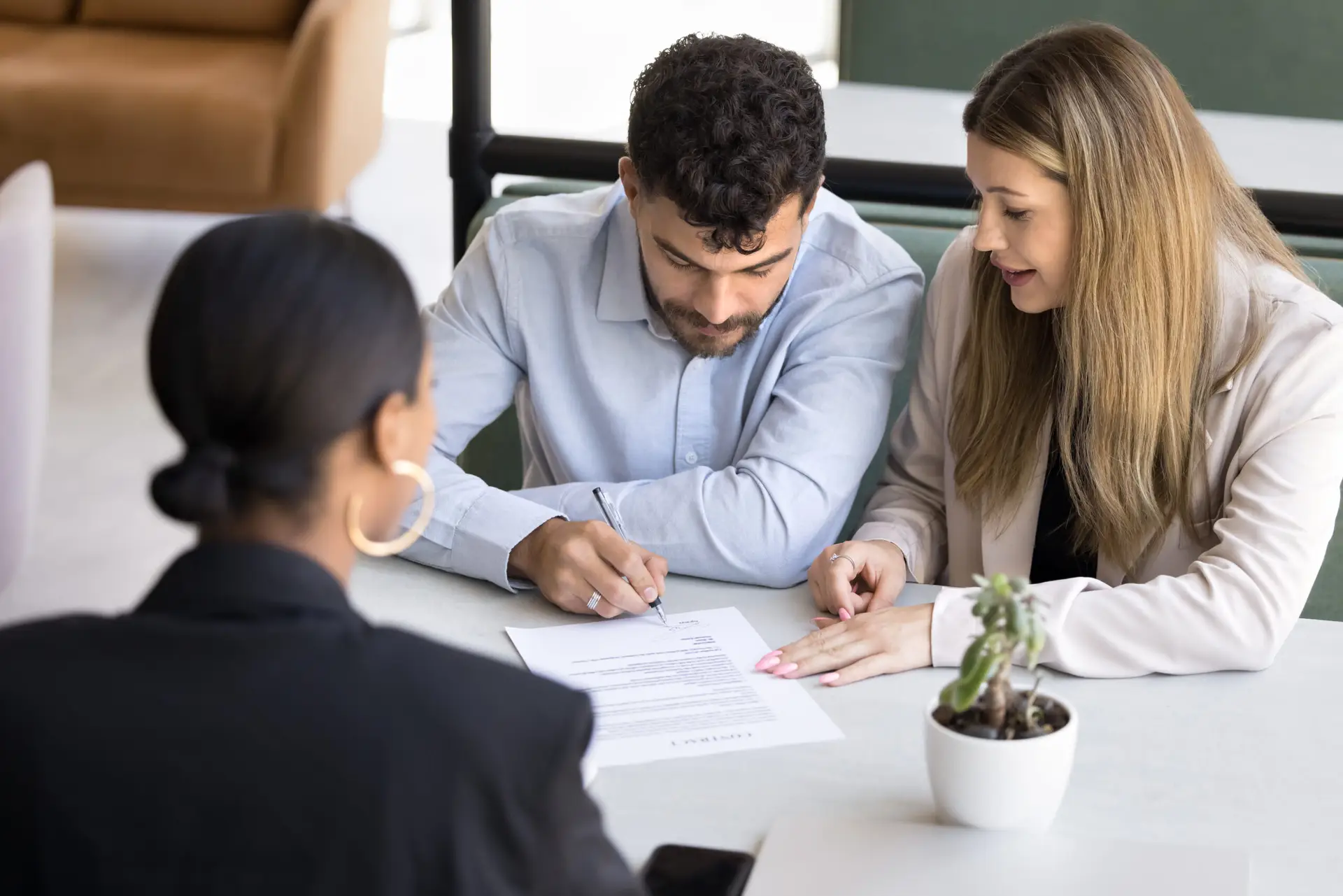 Focused married couple signing document, insurance agreement