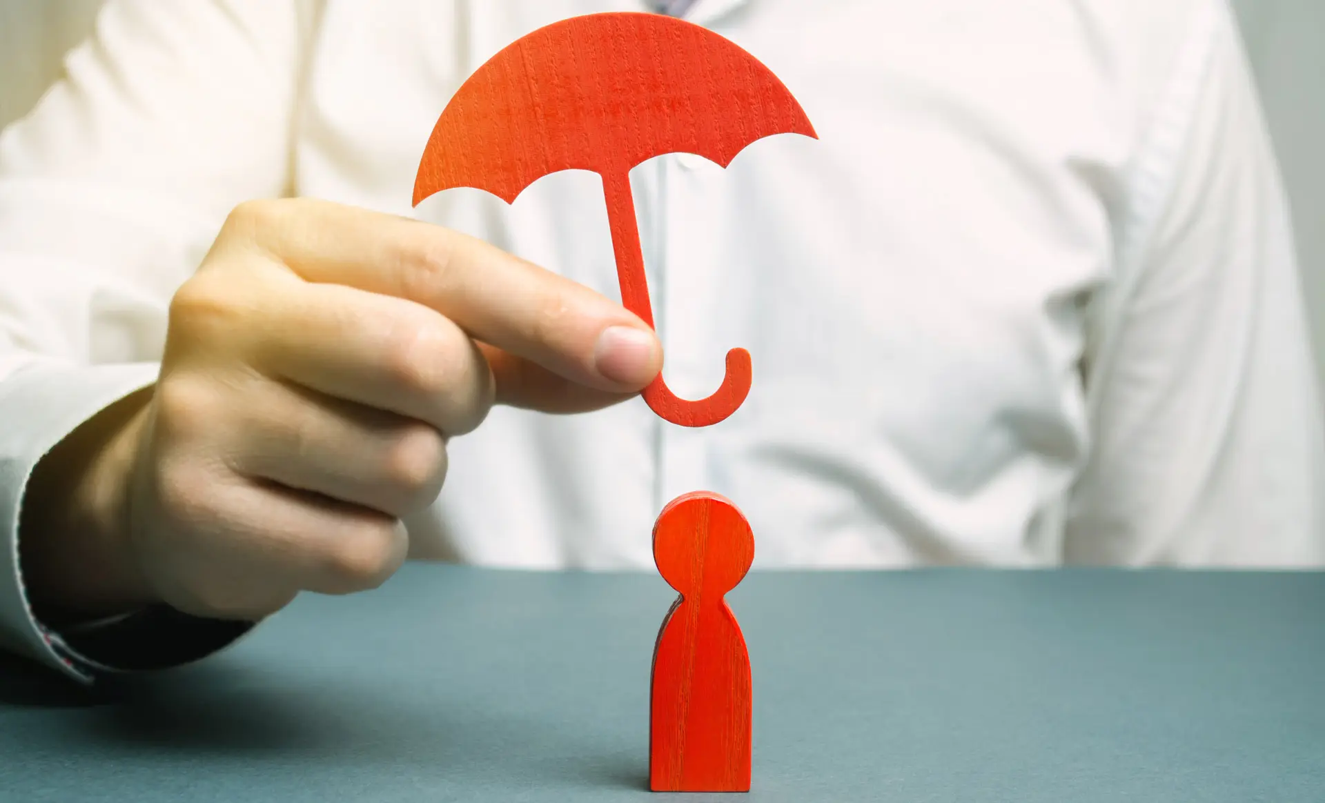 business-person-holds-red-umbrella-over-human-figure