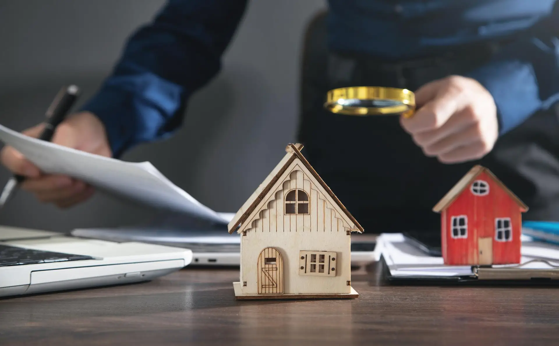house-model-desk-real-estate-agent-holding-magnifying-glass-document-office