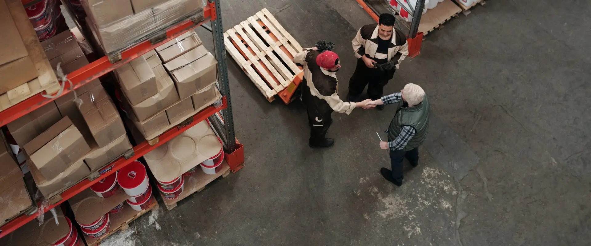 men-shaking-hands-at-warehouse-of-imported-goods