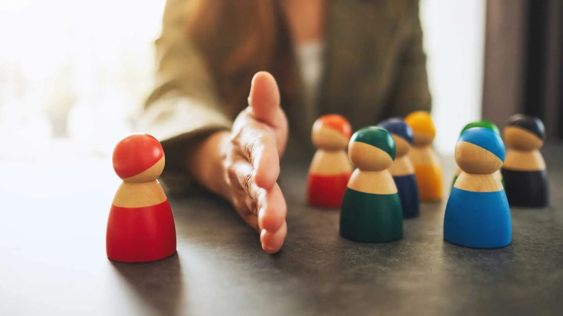 Concept of a business woman firing and rehiring an employee by separating one wooden people from a group